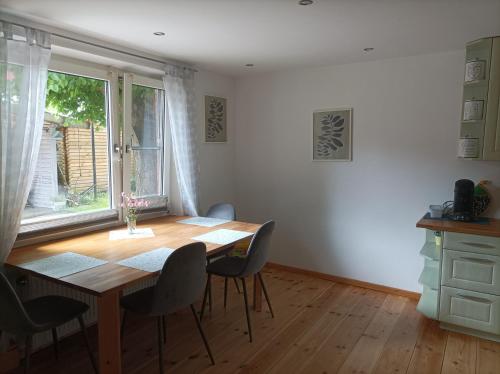 a dining room with a table and chairs and a window at Ferienwohnung Stapelmoor in Weener