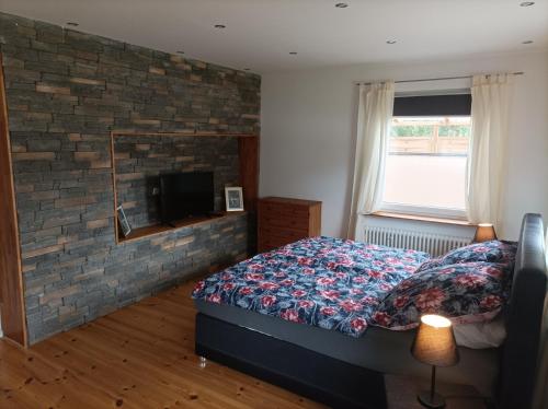 a bedroom with a bed and a brick wall at Ferienwohnung Stapelmoor in Weener