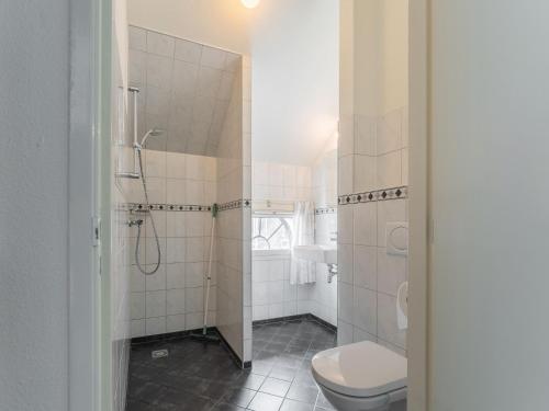 y baño blanco con aseo y ducha. en Spacious holiday home in Montfoort with private terrace en Montfoort