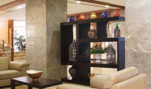 a living room with black shelves with vases on them at Hotel Plaza in Taranto