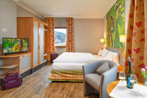 ザンクト・ゴアーにあるウィーンホテル ランツクネヒトのベッドとテレビが備わるホテルルームです。