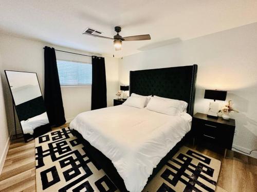 a bedroom with a large white bed with a ceiling fan at StarryNight at Museum Park - WORLD CUP in Houston