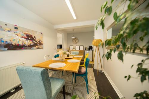 a dining room with a wooden table and blue chairs at Vila Ava in Zaprešić