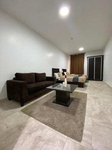 a living room with a couch and a table at Tunaib Plaza in Aţ Ţunayb