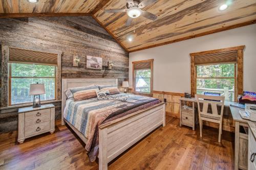 a bedroom with a bed and a desk at Brand New Build Luxury Mountain Chalet with Hot tub, pool, Game Room, Premium features in Ellijay