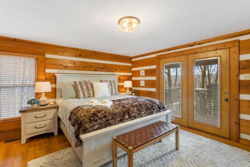 Schlafzimmer mit Holzwänden, einem Bett und einem Fenster in der Unterkunft Peek-a-Boo Lodge in Banner Elk