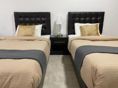 two beds sitting next to each other in a room at Tunaib Plaza in Aţ Ţunayb
