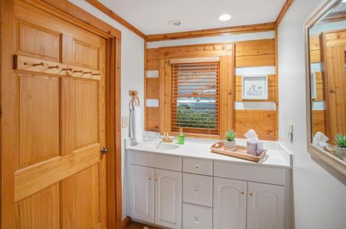 ein Badezimmer mit einem Waschbecken und einer Holztür in der Unterkunft Peek-a-Boo Lodge in Banner Elk