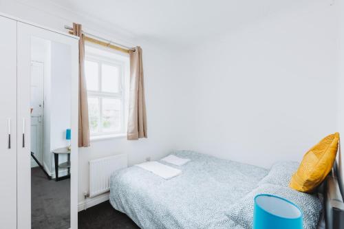 a bedroom with a bed and a window at The Dahlia Rooms - free parking & wifi in Barking