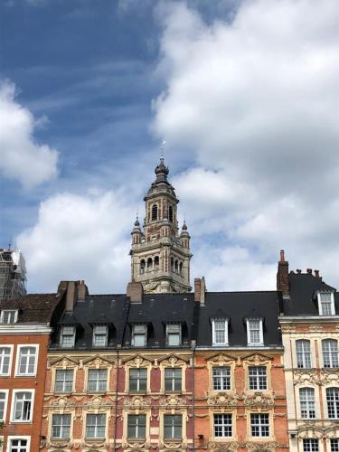 a building with a clock tower on top of it at Chambre dans maison cosy in Marquillies