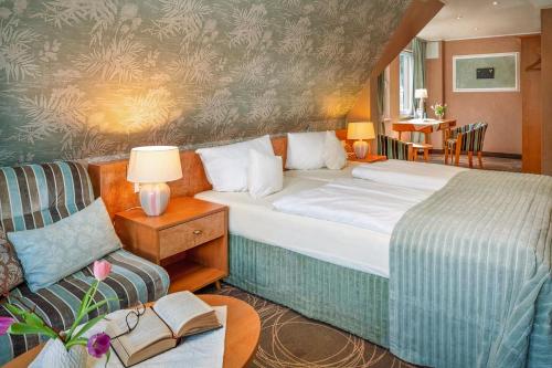 a hotel room with a bed and a couch at Weinhotel Landsknecht in Sankt Goar