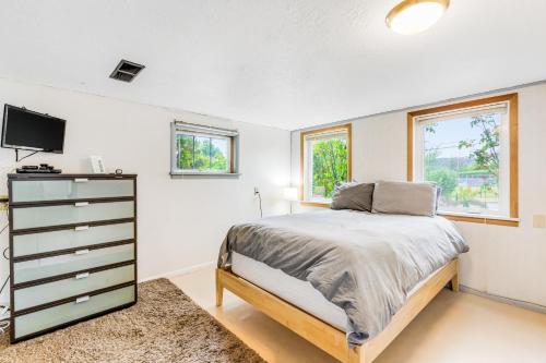 a bedroom with a bed and a tv and windows at Blanco Style in Poulsbo