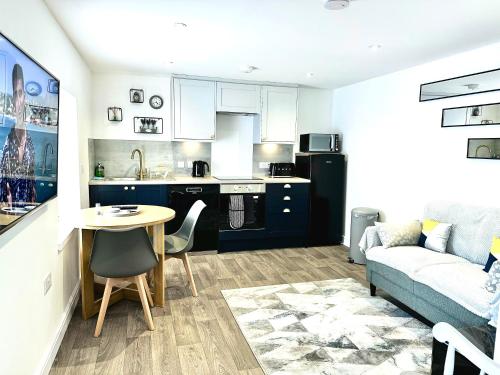 a kitchen and living room with a table and a couch at Central, Stylish - 2 Bed Property, The Stable @ Warrenfield, Free WiFi & Parking in Orkney