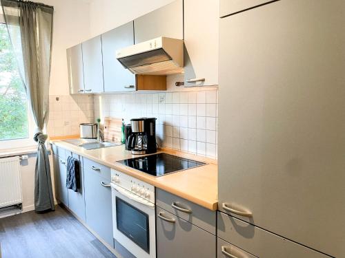 a kitchen with white cabinets and a refrigerator at Apartment für 3 Gäste Messe- und Citynah in Hannover