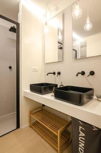a bathroom with a black sink and a mirror at Asinelli Luxury Apartment in Bologna