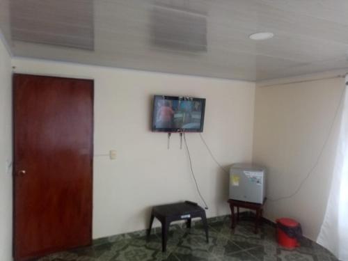 een kamer met een deur en een tv aan de muur bij PORTALES DEL LLANO in Villavicencio