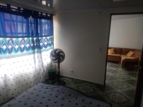 een kamer met een ventilator voor een raam bij PORTALES DEL LLANO in Villavicencio