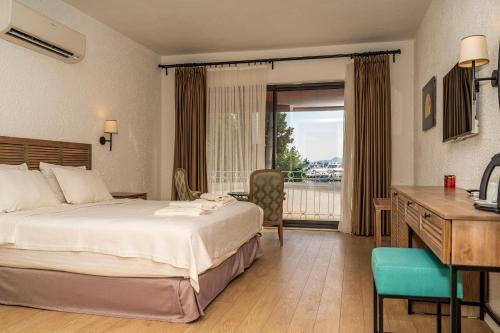 una camera d'albergo con letto, scrivania e finestra di Son2oda a Göcek