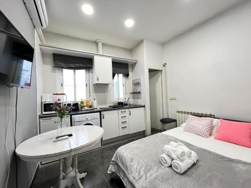 a bedroom with a bed and a table and a kitchen at Encantador Madrid Val Der in Madrid