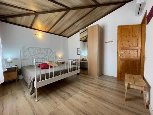 オロゼーイにあるSa Domo De Mannoiの白いベッドと木製の天井が備わるベッドルーム1室が備わります。