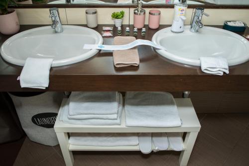 a bathroom with two sinks and towels on a counter at Vila Ava in Zaprešić