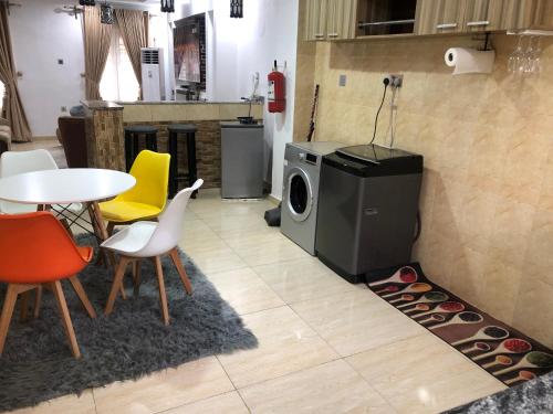 a kitchen with a washing machine and a table and chairs at Exquisite and Cozy 3-bedroom Apt with hot-tub, WiFi, DSTV, and Inverter Power Backup in Agege