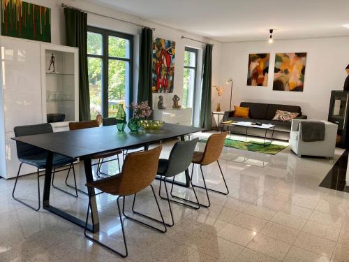 een woonkamer met een eettafel en stoelen bij Ferienhaus Ferienwohnung Potsdam DieGaLerie am Schlosspark Marquardt 