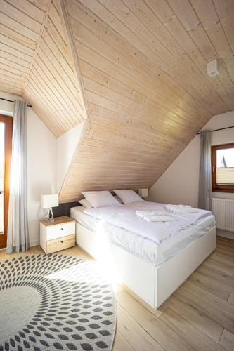 a bedroom with a large bed with a wooden ceiling at Uroczysko Lubajny in Idzbark