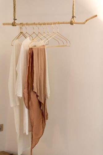 a rack of clothes hanging on a wall at Cleo's Dream Villa in Oia