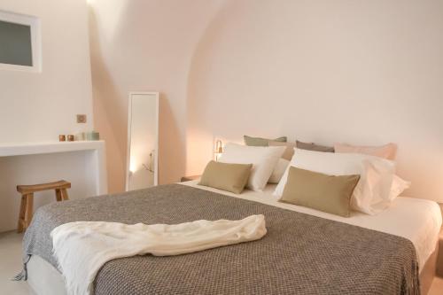 a bedroom with a large bed with white pillows at Cleo's Dream Villa in Oia