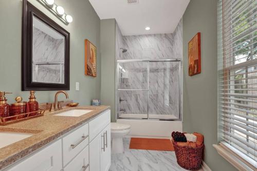 a bathroom with a sink and a toilet and a window at The Clark at Midtown Memphis in Memphis