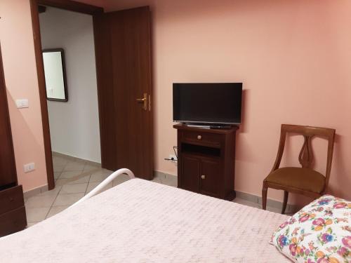 um quarto com uma cama e uma televisão de ecrã plano em La casetta di nonna Sesa em Viterbo