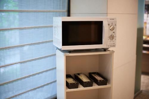 a microwave oven sitting on top of a shelf at Hotel Sunroute Ginza in Tokyo
