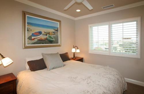 a bedroom with a bed and a picture of boats at 5 Bedroom Beachfront Masterpiece in Huntington Beach