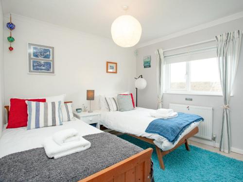 a bedroom with two beds and a window at Malborough Park in Malborough