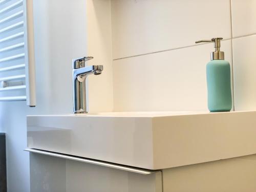 lavabo en el baño con una botella de jabón en una encimera en Wohnung für 3 Gäste mit kostenlosen Parkplätzen nah am Maschsee, en Hannover