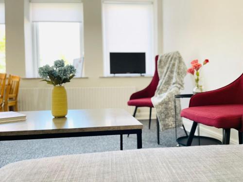 a room with two chairs and a table with a vase at Scandinavian Apartment Hotel - Tobaksgården - 2 room apartment in Horsens