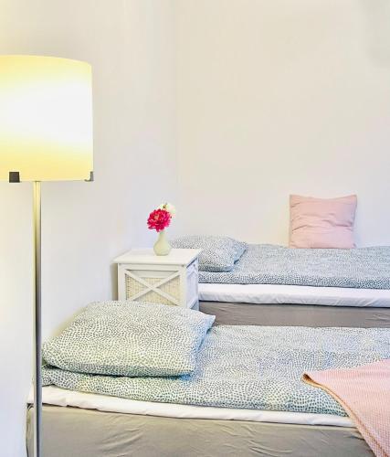 two beds in a room with a lamp at Scandinavian Apartment Hotel - Tobaksgården - 2 room apartment in Horsens