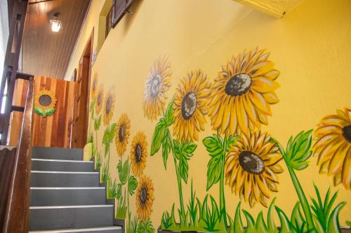 a mural of sunflowers on the wall of a hallway at POUSADA GIRASSOL in Santo Antônio do Pinhal