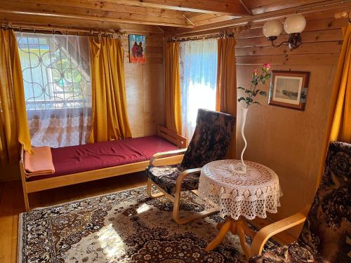 een kamer met een bed, een stoel en een tafel bij Domek Myśliwski Wilkasy Zalesie in Wilkasy