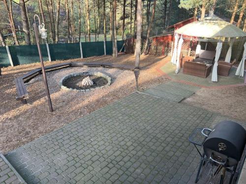 a backyard with a gazebo and a fire pit at Siedlisko Musialove nad jeziorem 8 osob in Łężce