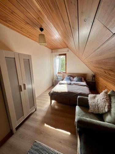 a bedroom with a bed and a couch in a room at Siedlisko Musialove nad jeziorem 8 osob in Łężce