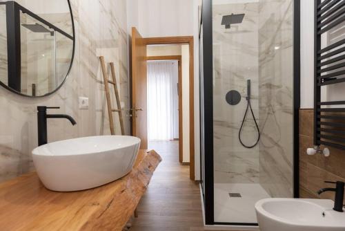 La salle de bains est pourvue d'une grande baignoire blanche et d'une douche. dans l'établissement Da Zietta casa dal sapore tipico, à Castellana Grotte