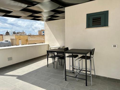 a black table and chairs on a roof at La Corte 25 in Marsala