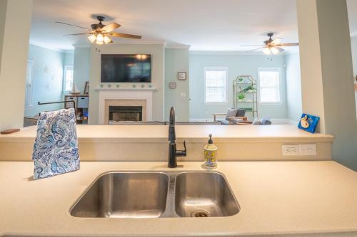 eine Küche mit einem Waschbecken und ein Wohnzimmer in der Unterkunft The Starfish Cove in Carolina Beach