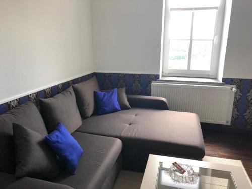 a living room with a couch with blue pillows at Ferienwohnung Ostwind in Schüller