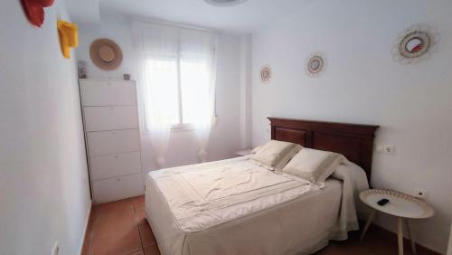 een witte slaapkamer met een bed en een raam bij Viajero del Sol El Morche Torrox Costa Málaga in Morche