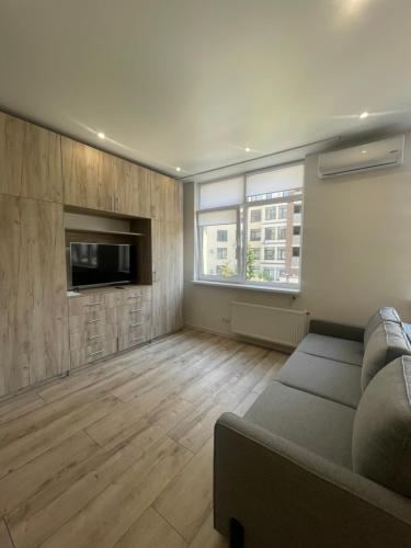 uma sala de estar com um sofá e uma televisão de ecrã plano em Residential complex Parkland em Kiev