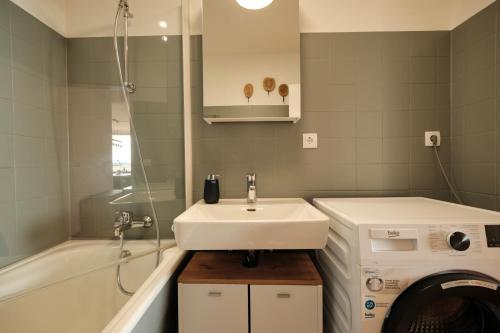 a bathroom with a sink and a washing machine at Seeblick - 4-Zimmer Wohnung in Immenstaad am Bodensee