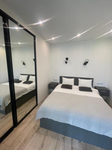 1 dormitorio con cama y espejo grande en Residential complex Parkland en Kiev